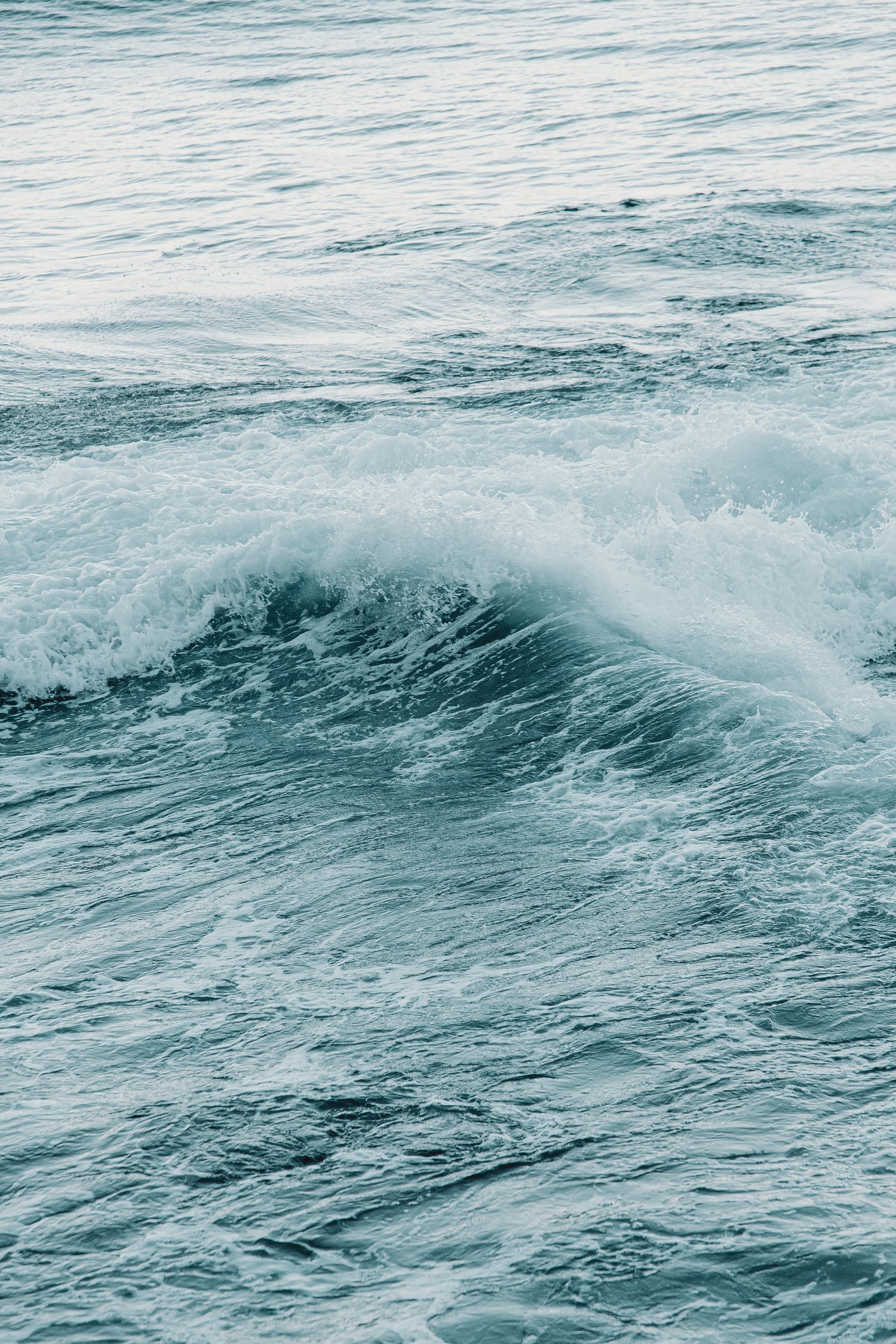 A large wave crashing with lots of seafoam and splash